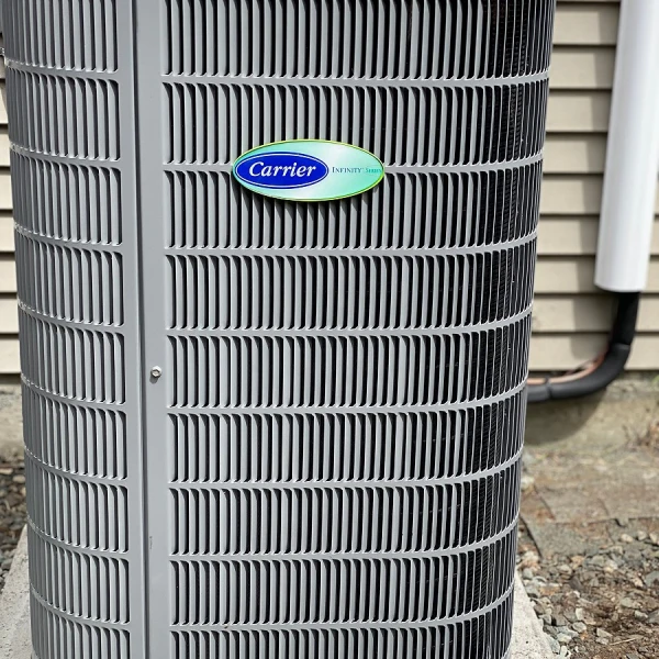 Close up view of a Carrier Infinity Series A/C unit, with focus on the Carrier logo and vertical fins in the design of the unit